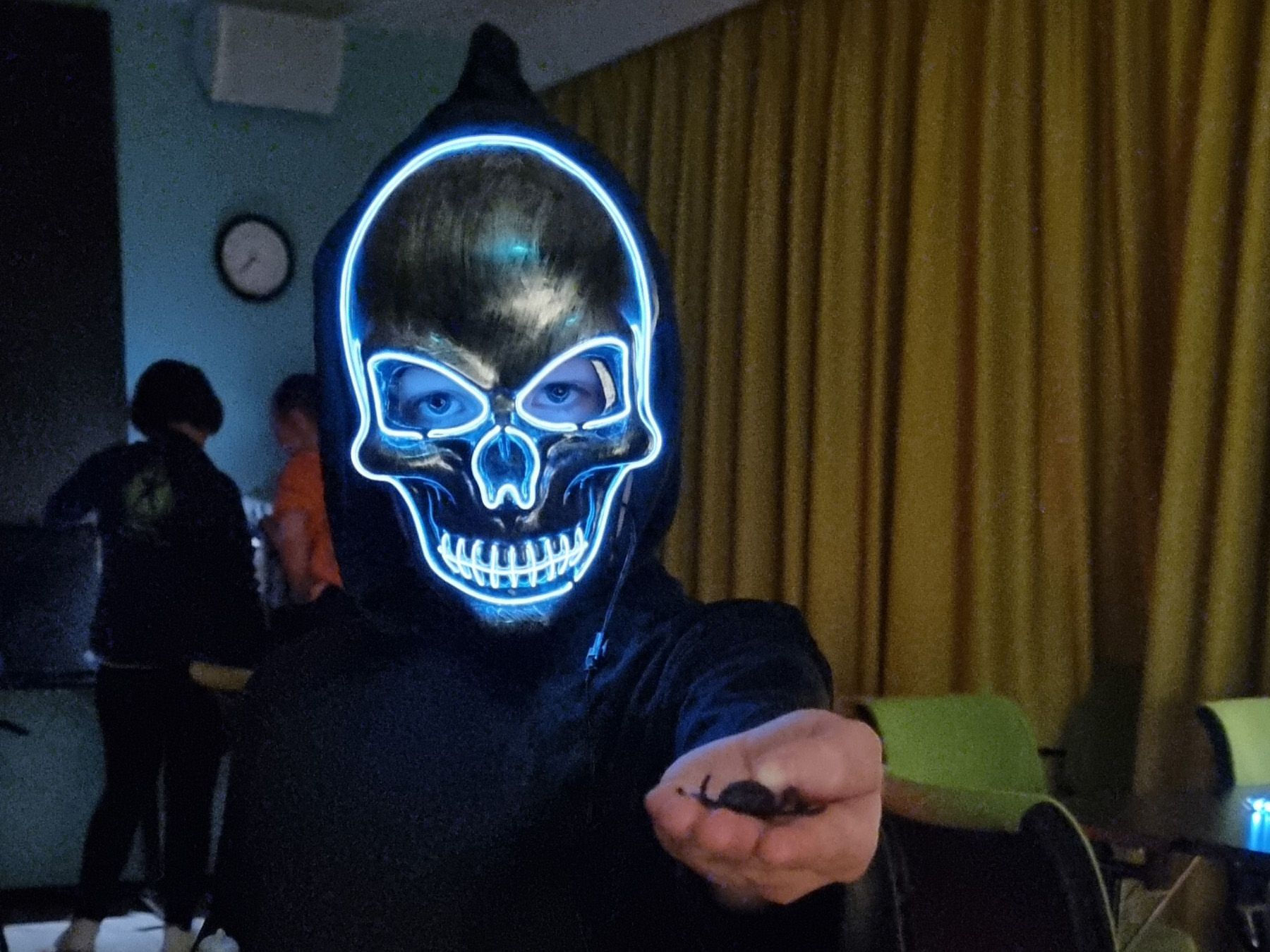 Barn kledd ut med LED-maske og sort kappe