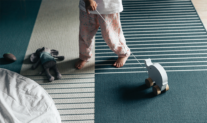  Lite barn som drar en lekeelefant over teppet