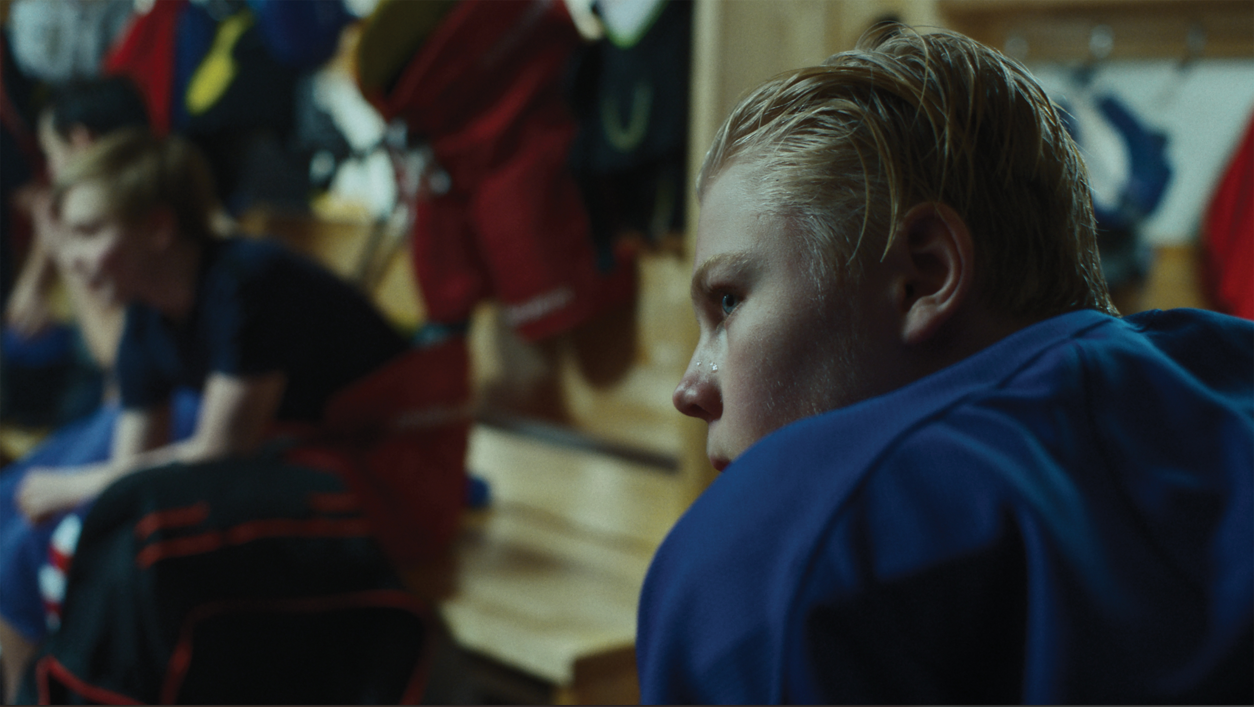 Ung gutt som sitter i garderoben etter hockey-trening